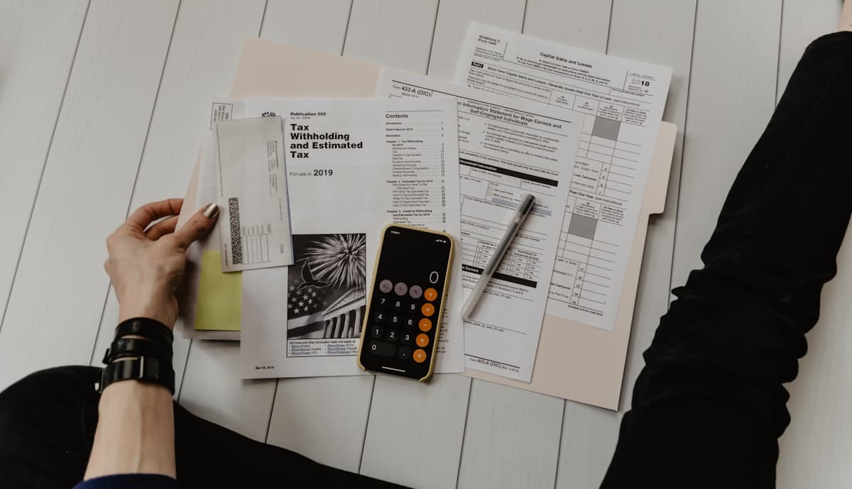 Financial documents and calculator for home service advertising budget planning