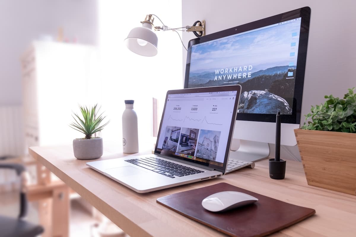 Laptop and monitor on desk showing website design and analytics